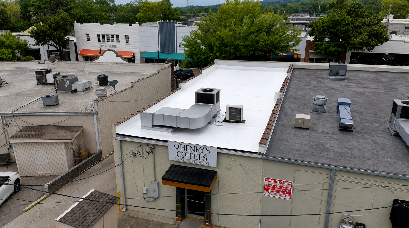 White flat membrane roof with rooftop HVAC units above O'Henry's Coffees, Homewood AL